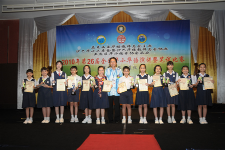 沙巴发展华小工委会主席周惠卿与华语演讲比赛得奖者合影。