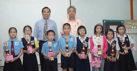 王超群（后左起）及谢立意颁发奖品给绘画比赛优胜学生。（图：星洲日报）