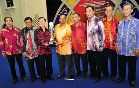 吉隆坡领队陈文化（左3）从玻璃市州务大臣马依沙（左4）手中接过常年杯。左起：玻州行政议员傅子初医生、以及玻州教育局总监顿卡沙；右起：玻璃市华校教师会主席梁兆壮、玻璃市华校董联会主席许高廷、教总主席王超群，以及玻州教育局小学组主任阿都拉沙菲益。（照片来源：星洲日报）