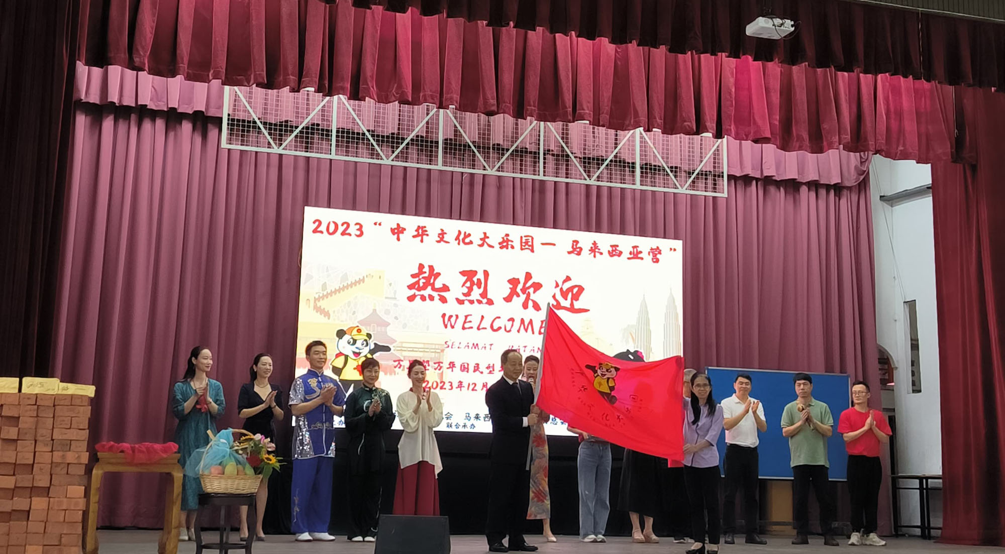 何新华处长把旗帜移交给方淑芬校长，正式拉开”中华文化大乐园“的帷幕