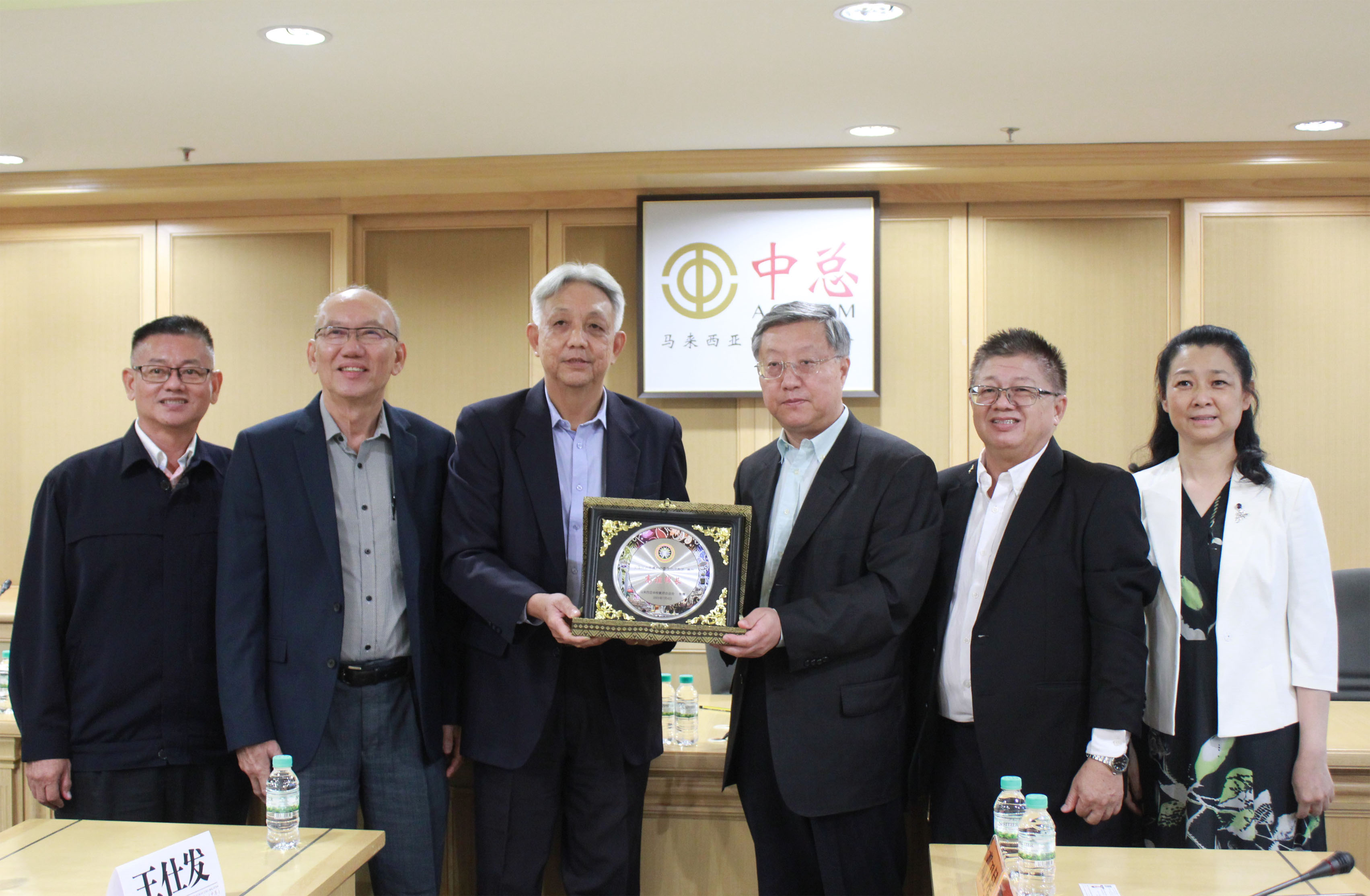 主席谢立意（左三）赠送纪念品予王伟副主任（右三）。左起：王金忠和李金桦。右起：刘以勤和王仕发